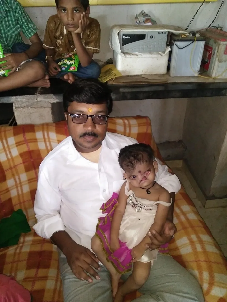 Ganesh Dalvi, founder of SaiAshraya Family, holding a child